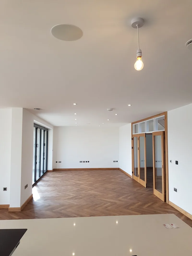 Bright open room with spotlights, a pendant light and a herringbone floor