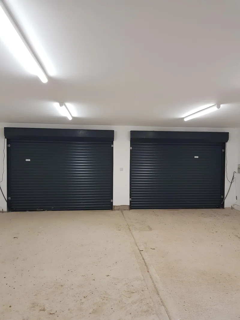Garage with two roller doors and strip lights on the ceiling